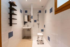 a bathroom with a shower and a sink and a stool at Chalet Belle Etoile Val de Tamié in Faverges
