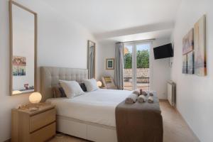 Un dormitorio con una gran cama blanca con zapatos encima. en Praia Areia Branca, en Lourinhã