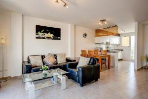 ein Wohnzimmer mit Sofa und Tisch in der Unterkunft Jardines de Denia in Denia