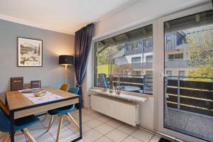 Un comedor con una mesa y un gran ventanal. en Ferienwohnung Schanze Willingen, en Stryck