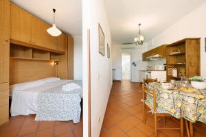 a room with a bed and a table and a kitchen at Appartamento Celsi in Moneglia