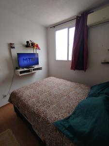 a bedroom with a bed and a window and a tv at Pinheiros in Várzea Grande +1 photo
