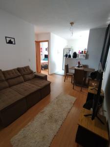a living room with a couch and a dining room at Pinheiros in Várzea Grande