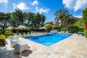una imagen de una piscina con sillas y árboles en Can Toni, en Port de Pollença (Puerto Pollensa)