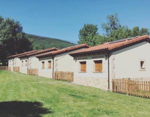 a row of white buildings with a grass yard at El Aterpe 3 in Aldehuela del Rincón