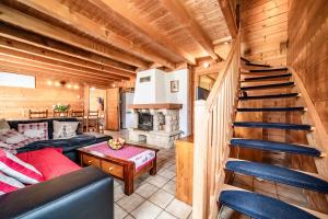 a living room with a staircase in a log cabin at Chalet Marmottes in Morillon