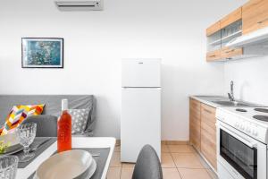 een keuken met een tafel en een keuken met een koelkast bij Sea Apartment Ixia Ialisos in Ialyssos +2 foto's