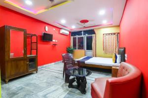 a room with red walls and a bed and a table at Hotel O Bright in Jamshedpur