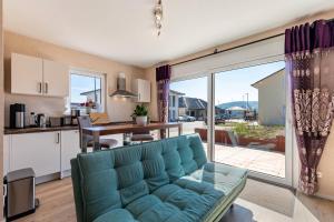 ラインベレンにあるFeel Free Appartmentの青いソファとキッチンのあるリビングルーム