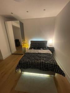 a bedroom with a bed with a black and white comforter at Welcoming Home in London