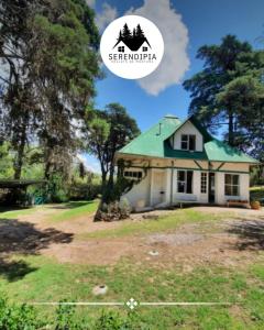 a house with a green roof on a yard at Serendipia Chalet 1 Naturaleza y Pileta in La Cumbre