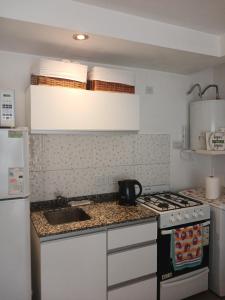 a small kitchen with a stove and a sink at Hermoso Departamento en Temperley in Temperley +7 photos