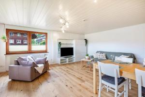 a living room with a table and a dining room at Ferienwohnung Käppeleblick in Bernau im Schwarzwald