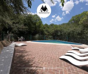 a resort with a swimming pool with lounge chairs at Serendipia Chalet 1 Naturaleza y Pileta in La Cumbre