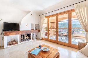 a living room with a fireplace and a tv at Montemar 36 in Port de Soller