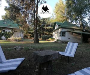 two chairs and a table in front of a house at Serendipia Chalet 1 Naturaleza y Pileta in La Cumbre +8 photos
