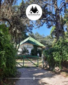a gate in front of a house with a tree at Serendipia Chalet 1 Naturaleza y Pileta in La Cumbre