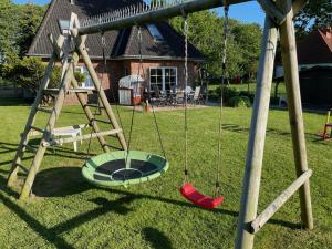 诺德代希Ferienhaus Immerlicht Norddeich S-H的院子里空摆摆摆的摆摆架
