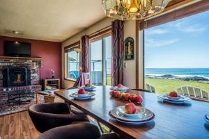 a dining room with a table and chairs and a fireplace at Oceanfront Wave Watching with Hot Tub! Beyond the Sea in Yachats