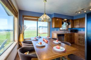 a dining room with a table and chairs and a kitchen at Oceanfront Wave Watching with Hot Tub! Beyond the Sea in Yachats