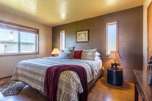 a bedroom with a bed and two windows at Oceanfront Wave Watching with Hot Tub! Beyond the Sea in Yachats