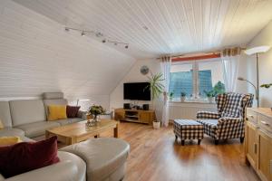 a living room with a couch and chairs and a tv at Micha's Ferienwohnung in Bredstedt