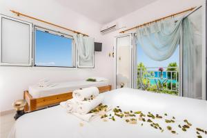 two beds in a white room with a window at Tamar Apartments, Alikanas in Alikanas
