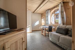 a living room with a couch and a flat screen tv at L'epilobe in La Plagne Tarentaise