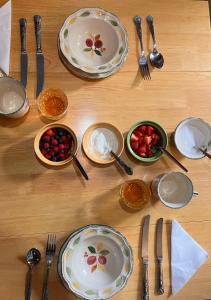 a wooden table with plates and forks and spoons at Charming Guest House in Cornish Countryside in Bodmin +20 photos