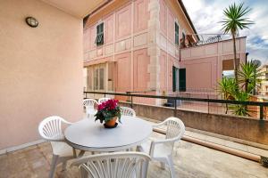 a white table and chairs on a balcony at Casa Rosa in Loano