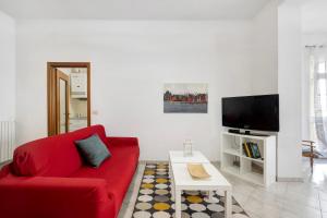 a living room with a red couch and a tv at Casa Rosa in Loano
