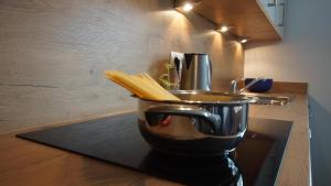 Un exprimidor con fideos en una olla sobre la encimera de la cocina. en Ferienwohnung Mario, en Hippach