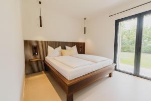 a bedroom with a bed with white sheets and a window at Lagolino Boutiquehouse in Pacengo di Lazise