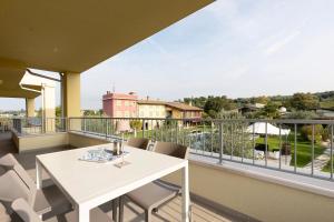a balcony with a white table and chairs at Agriturismo Le Campagnole Red in Bardolino
