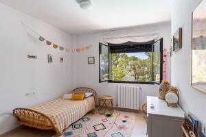 a bedroom with a bed and a window at Ses Buguenvílies in Marratxí 