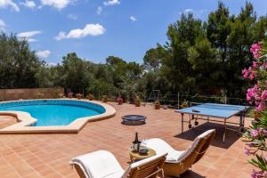 a patio with a pool and a table and chairs at Ses Buguenvílies in Marratxí 