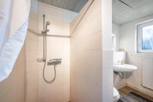 a white bathroom with a shower and a sink at Eggert, Ingelore und Manfred in Immenstedt +41 photos
