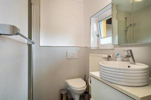 a bathroom with a sink and a toilet and a mirror at Eigentumswohnung mit Seeblick in Lindau +13 photos