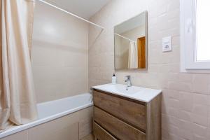 a bathroom with a sink and a tub and a mirror at Noria 1 in El Pozo de los Frailes +13 photos