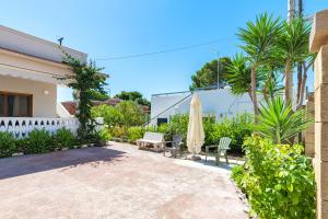 un patio con un ombrellone, una sedia e un ombrellone di Villa Bianca a Pulsano