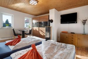 a bedroom with two beds and a flat screen tv at Ferienhaus Tanneberg in Tanneberg