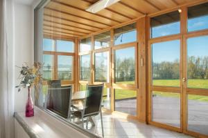 une salle à manger avec des portes en verre et une table avec des chaises dans l'établissement Pur Wohnen - Wohnung West, à Bad Griesbach im Rottal