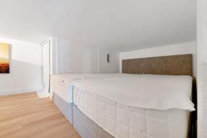 a white bedroom with a large white bed in it at Ferienwohnung Meerblick in Strande