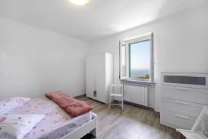 une chambre blanche avec un lit et une fenêtre dans l'établissement Chiara du Ciapin - Osservatorio, à Cogoleto