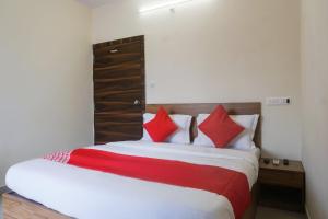 a bedroom with a large bed with red pillows at Collection O Palm Bliss in Kharadi +27 photos