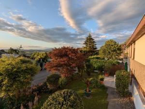 vistas a un patio con árboles y plantas en Ferienwohnung Schwarzwaldblick, en Weil am Rhein