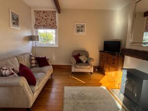 ein Wohnzimmer mit Sofa und Fernseher in der Unterkunft Stable Cottage Lytham in Lytham St Annes