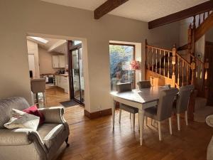 a dining room with a table and chairs and a kitchen at Stable Cottage Lytham in Lytham St Annes