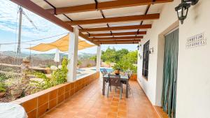 an outdoor patio with a table and an umbrella at Villa Florencia in Frigiliana
