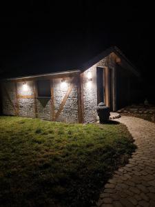 une maison en pierre la nuit avec des lumières allumées dans l'établissement Freiraum - Wohnen Auf Zeit, à Thanheim